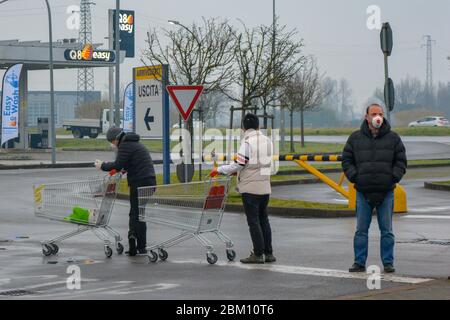 Lucca, Italien 03/12/20: Mann trägt eine Schutzmaske in der Linie mit dem Warenkorb zum Vorrat von Lebensmitteln. Soziale Distanz und Stress in Italien Stockfoto