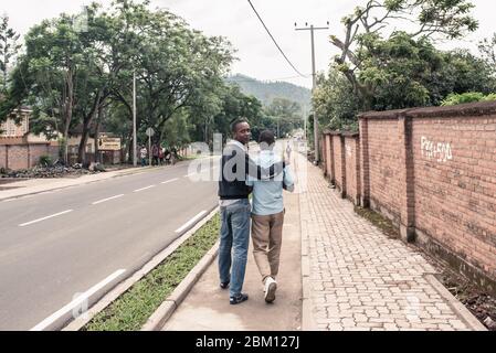 Gisenyi, Ruanda - 25. Oktober 2016: Zwei junge Afrikaner, die sich in den Straßen von Gisenyi, Ruanda umarmen Stockfoto