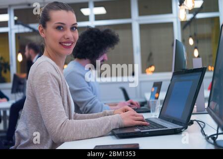 Porträt der jungen schönen glücklich casual Geschäftsfrau an ihrem Arbeitsplatz in modernen CO-Arbeitsraum. Stockfoto