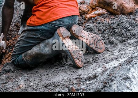 Kumasi,Ghana - 20. April 2020: Menschen, die Bohrlöcher mit Bohrmaschine machen und sich auch müde fühlen Stockfoto