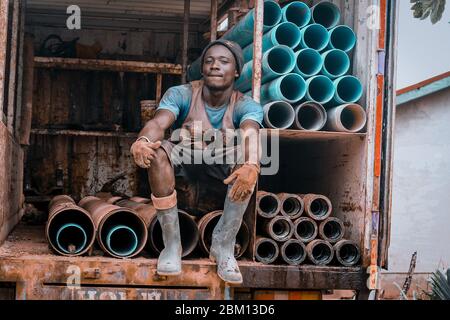 Kumasi,Ghana - 20. April 2020: Menschen, die Bohrlöcher mit Bohrmaschine machen und sich auch müde fühlen Stockfoto