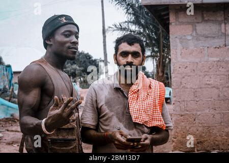 Kumasi,Ghana - 20. April 2020: Menschen, die Bohrlöcher mit Bohrmaschine machen und sich auch müde fühlen Stockfoto