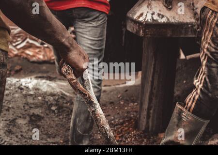 Kumasi,Ghana - 20. April 2020: Menschen, die Bohrlöcher mit Bohrmaschine machen und sich auch müde fühlen Stockfoto