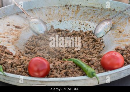 Traditionelles türkisches Shawarma-Fleisch, das mit roten Tomaten und roten und grünen Paprika zubereitet wird, erhältlich auf einem Straßenmarkt, selektiv Stockfoto