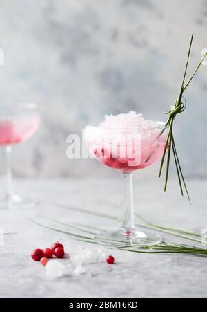 Rosa Mocktail Nahaufnahme. Getränk mit Rose und Prosecco in Trinkware. Exotische französische Martini-Cocktailportion mit zerdrücktem Eis in Glaswaren Stockfoto