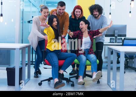 Eine Gruppe von Mitarbeitern im Kreativbüro arbeiten zusammen und machen während ihrer Arbeit im Büro einen Scherz miteinander. Erfolg und Wettbewerb Business Co Stockfoto