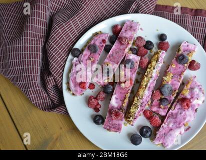 Hausgemachte rosa gefrorene Joghurtbars mit Himbeeren und Heidelbeeren. Snack für die Sommertage Stockfoto