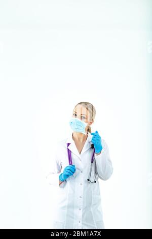 Die Krankenschwester zieht eine Schutzmaske an. Eine Krankenschwester in einer Atemmaske. Masken anziehen. Tragen Sie Handschuhe. Schöne blonde Arzt zeigt, wie man auf einen Schutz setzen Stockfoto