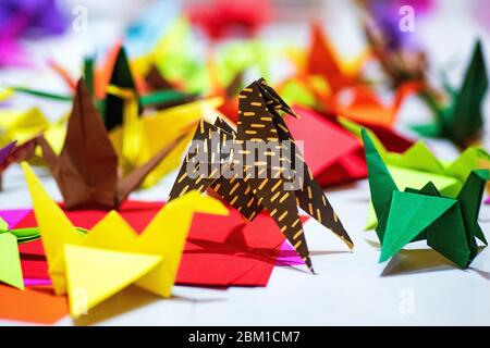 Papierkrane aus mehrfarbigem Papier. Japanisches Origami aus farbigem Papier.Bunte Origami Papier Krane Hintergrund Stockfoto