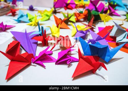 Papierkrane aus mehrfarbigem Papier. Japanisches Origami aus farbigem Papier.Bunte Origami Papier Krane Hintergrund Stockfoto