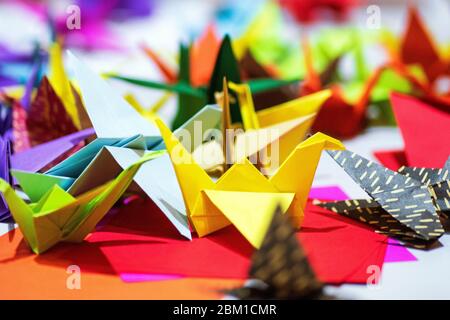 Papierkrane aus mehrfarbigem Papier. Japanisches Origami aus farbigem Papier.Bunte Origami Papier Krane Hintergrund Stockfoto