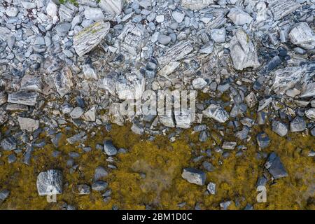 Luftaufnahme von oben auf die Wellen, die auf die Felsen am Strand treffen. Stockfoto