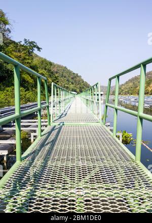 Lange Metallbrücke schwimmt auf dem Stausee für den Einsatz, um zur Wasserpumpstation zu gehen, für Wasserwerke in der ländlichen Umgebung. Stockfoto