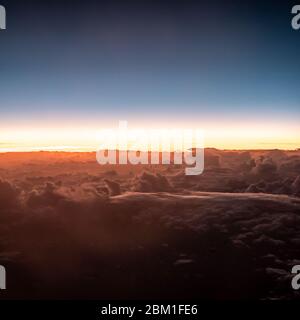 Sonnenuntergang über den Wolken. Ein Luftbild über den Wolken, wenn die Sonne vorbeigeht und die Nacht naht. Stockfoto