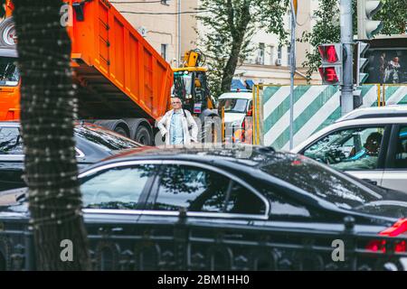 Moskau, Russland - 7. JULI 2017: Ein älterer Mann wartet darauf, dass die Ampel an einem Fußgänger vorbeikommt. Starker Verkehr von Autos im Vordergrund Stockfoto