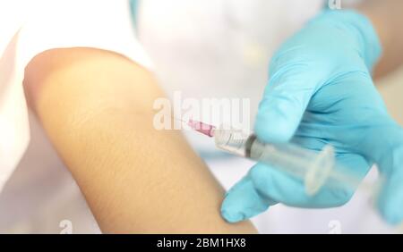 Arzt injiziert Medikamentendosis in seinen Arm durch Verwendung von Spritze. Drogenabhängige Injektion Drogen Konzept. Stockfoto