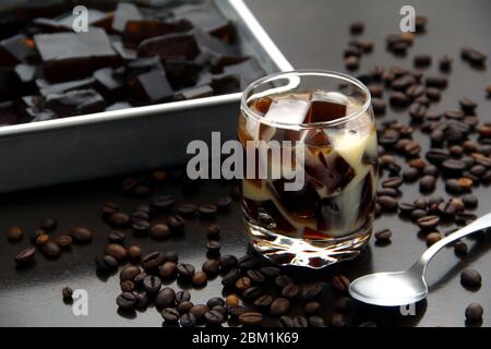 Foto von Kaffee gewürzt Gelee mit Milch in einem klaren Glas auf einem Tisch. Stockfoto