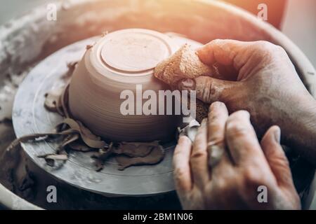 Meister der alten Faltenhand arbeitet am Töpferrad. Konzept Ausdauer und Geduld. Stockfoto