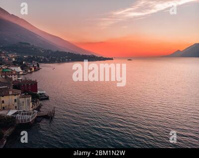 Lago Garda - Blick auf das Dorf Malcesine. Alte Burg auf dem Felsen Italien. Sonnenuntergang mit Luftbild Stockfoto