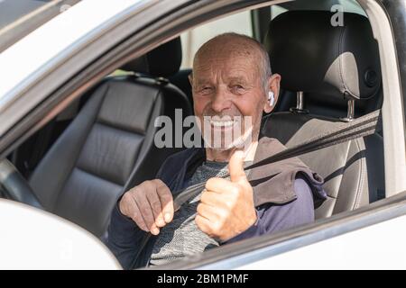 Lächelnd glücklich älteren Mann im neuen Auto mit Daumen nach oben Stockfoto