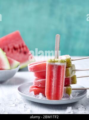 Teller mit gesunden hausgemachten Wassermelonen-Stielchen mit frischen Früchten und Eis Stockfoto