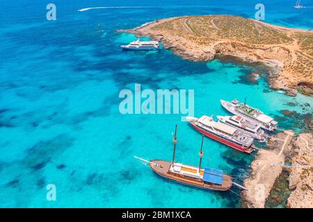 Konzept Paradies Urlaub. Weiße Yacht mit Segel in klarem Wasser des Meeres mit Sand. Blaue Lagune Comino Malta. Luftaufnahme Stockfoto