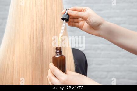 Master Friseur Verfahren Öl Haarbehandlung für Frau. Konzept Spa Salon. Stockfoto