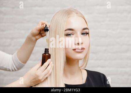 Master Friseur Verfahren Öl Haarbehandlung für Frau. Konzept Spa Salon. Stockfoto