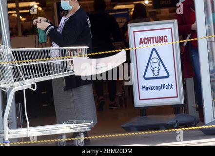 Berlin, Deutschland. Mai 2020. Ein Schild am Eingang eines Marktes informiert die Besucher, dass sie Schutzmasken tragen sollten. Quelle: Wolfgang Kumm/dpa/Alamy Live News Stockfoto