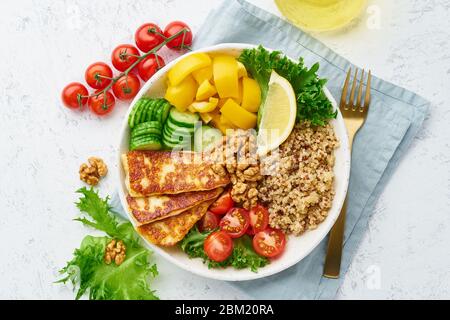 Buddha-Schüssel mit Halloumi, Quinoa, Salatsalat, ausgewogenem Essen, weißem Hintergrund, Draufsicht Stockfoto