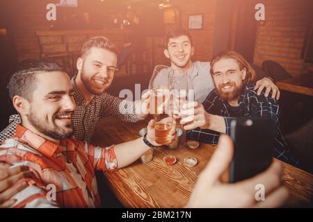 Männliche Freunde machen Selfie-Foto auf Telefon mit Gläsern Bierbar Pub. Konzept der Freundschaft Stockfoto