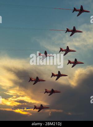 Die britischen roten Pfeile fliegen während des Sonnenuntergangs. Stockfoto