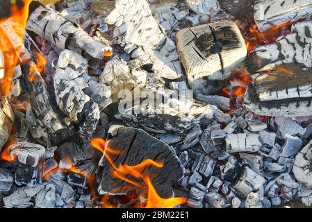 Schwarze heiße Kohlen in einem Hochofen für Metallschmelzen. Metallbergbau und verarbeitende Industrie. Schwarze Kohlen aus einem verbrannten Feuer aus Holz Stockfoto