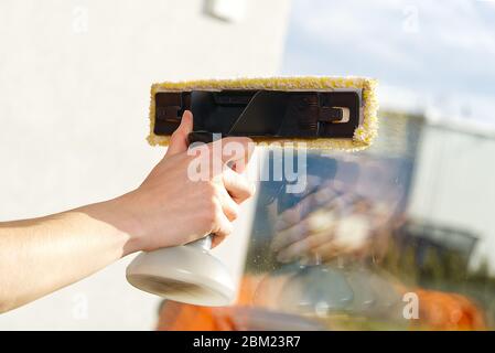 Frühjahrsputz eines schmutzigen Fensters. Service für das Waschen von Fenstern in Wohnhäusern. Frau bietet einen Fensterreinigungsservice. Reinigungskonzept Stockfoto