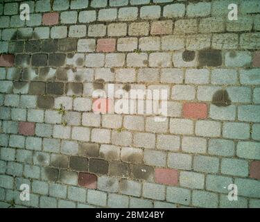Isolierte Nahaufnahme von alten kontrastreiche Hydrauliköl Lenkflüssigkeit Leck Flecken von alten Auto auf Block Fertiger gepflasterte Auffahrt vor der Reinigung Stockfoto