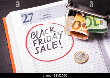 Datum für den Black Friday Sale in einem Kalender, auf dem Münzen und Banknoten vorhanden sind Stockfoto