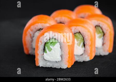 Eine Portion frisches philadelphia Sushi Rolle auf schwarzem Hintergrund Stockfoto