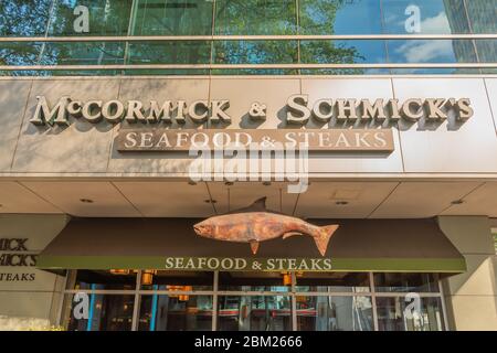 Charlotte, NC/USA - 26. Mai 2019: Fassade des McCormick & Schmick's Seafood & Steaks' Restaurants mit Marke in weißen Buchstaben und hängenden Fischzeichen. Stockfoto