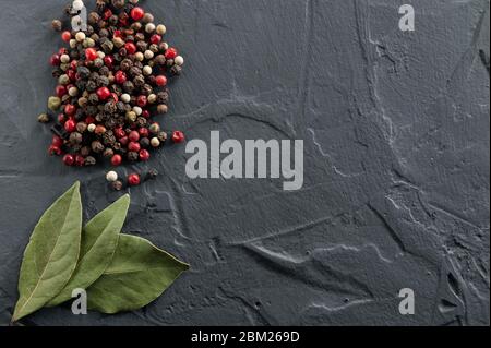 Gewürze - Knoblauch, Pfeffer, Lorbeerblatt auf grauem Hintergrund Stockfoto