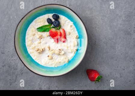 Portion Haferflocken mit Erdbeere, Heidelbeere, Minze in der Schüssel Stockfoto