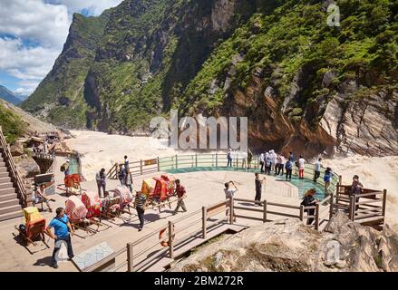 Jizha, China - 24. September 2017: Menschen am Aussichtspunkt der Tiger Leaping Gorge für raues Wasser. Es ist Teil der drei parallelen Flüsse von Yunnan schützen Stockfoto