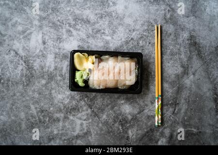 Zum Mitnehmen Suzuki Fisch Sashimi mit eingelegtem Ingwer und Wasabi in schwarzem Kunststoff-Teller-Container / Paket. Traditionelles Fast Food. Bereit zum Essen. Stockfoto