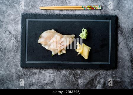 Suzuki Fish Sashimi mit eingelegtem Ingwer und Wasabi auf Black Stone Board. Traditionelle Bio Gesunde Lebensmittel. Stockfoto