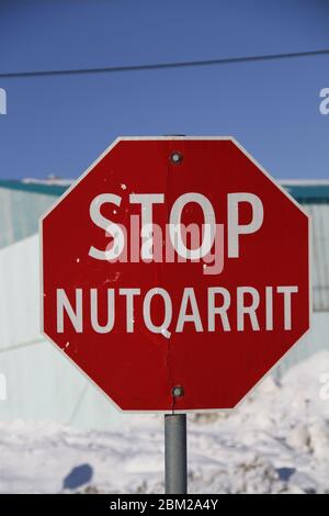 Rotes Stoppschild in Englisch und Inuinnaqtun in der Gemeinde Cambridge Bay, Nunavut Stockfoto