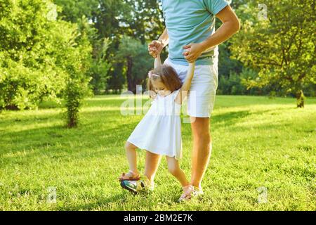 Vatertag. Vater spielt mit seiner Tochter auf dem Gras im Sommerpark an einem sonnigen Tag. Stockfoto