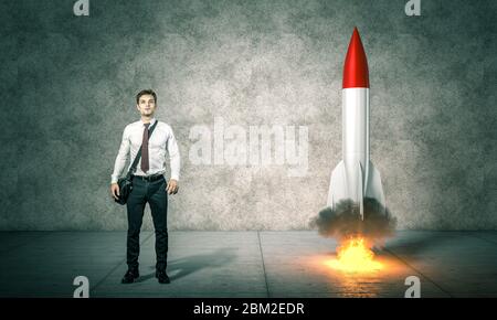 Geschäftsmann steht neben einer neu gestarteten Rakete. Konzept des Startens Aspiration, Erfolg, Innovation. Stockfoto