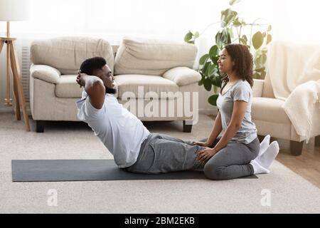 Verheiratet Afrikanischen Paar Tun Fitness-Training Zu Hause Zusammen Stockfoto