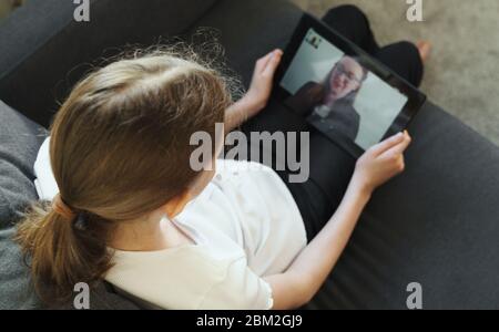 Kleines Mädchen, das Videoanruf mit Schullehrerin oder Mutter macht. Stockfoto