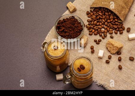 Dalgona Kaffee im Einmachglas. Koreanischer flauschiger Schlagkaffee. Trendiges Quarantänegetränk, Zucker und Kaffeebohnen auf schwarzem Steinbeton-Hintergrund Stockfoto