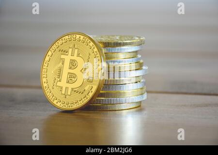 Stapeln Sie goldene und silberne Kryptowährungen zusammen. Vor ihm ist ein Goldbitcoin. Neue virtuelle Geldmünzen Stockfoto